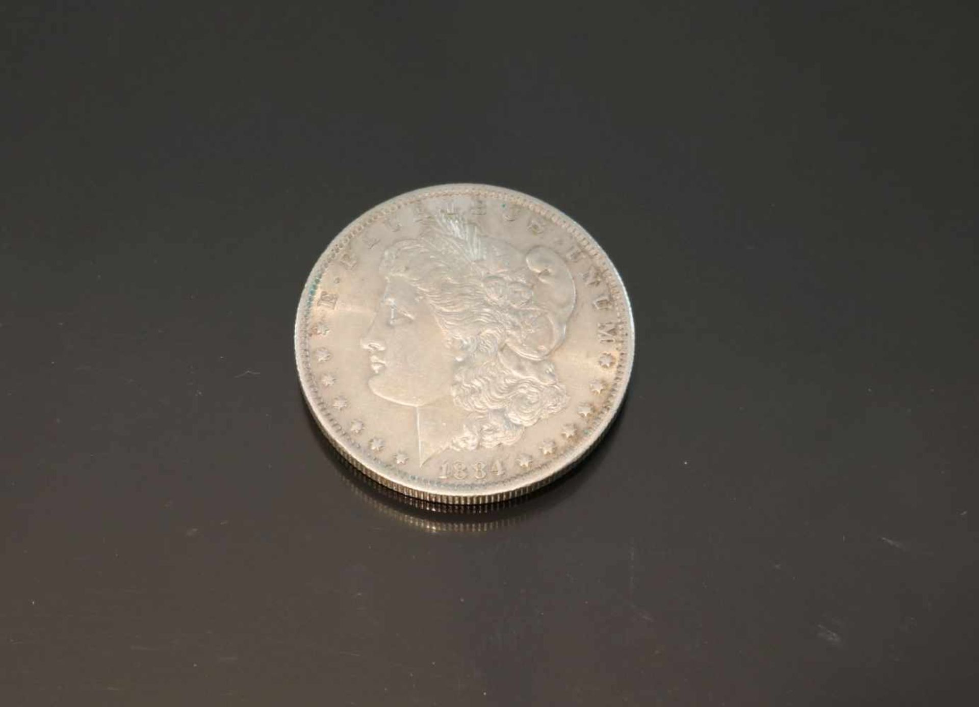 One Dollar 1884, USA, Morgan DollarMaterial: SilberPrägebuchstabe: oGewicht: 26,8 Gramm Größe: 37,