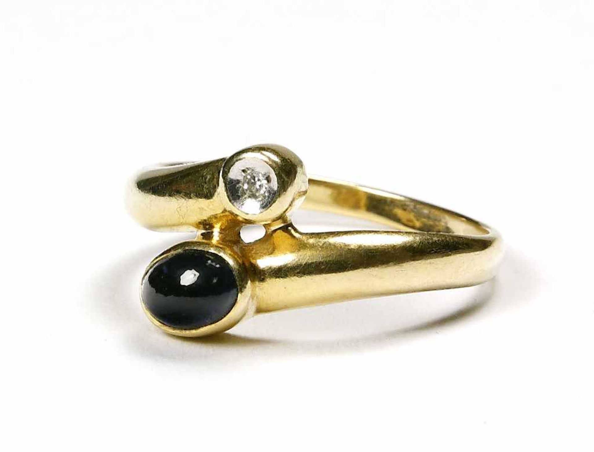 Ring, 585er GG. mit Saphircabochon und kleinem Diamant im Brillantschliff.Bruttogewicht ca. 4 g.