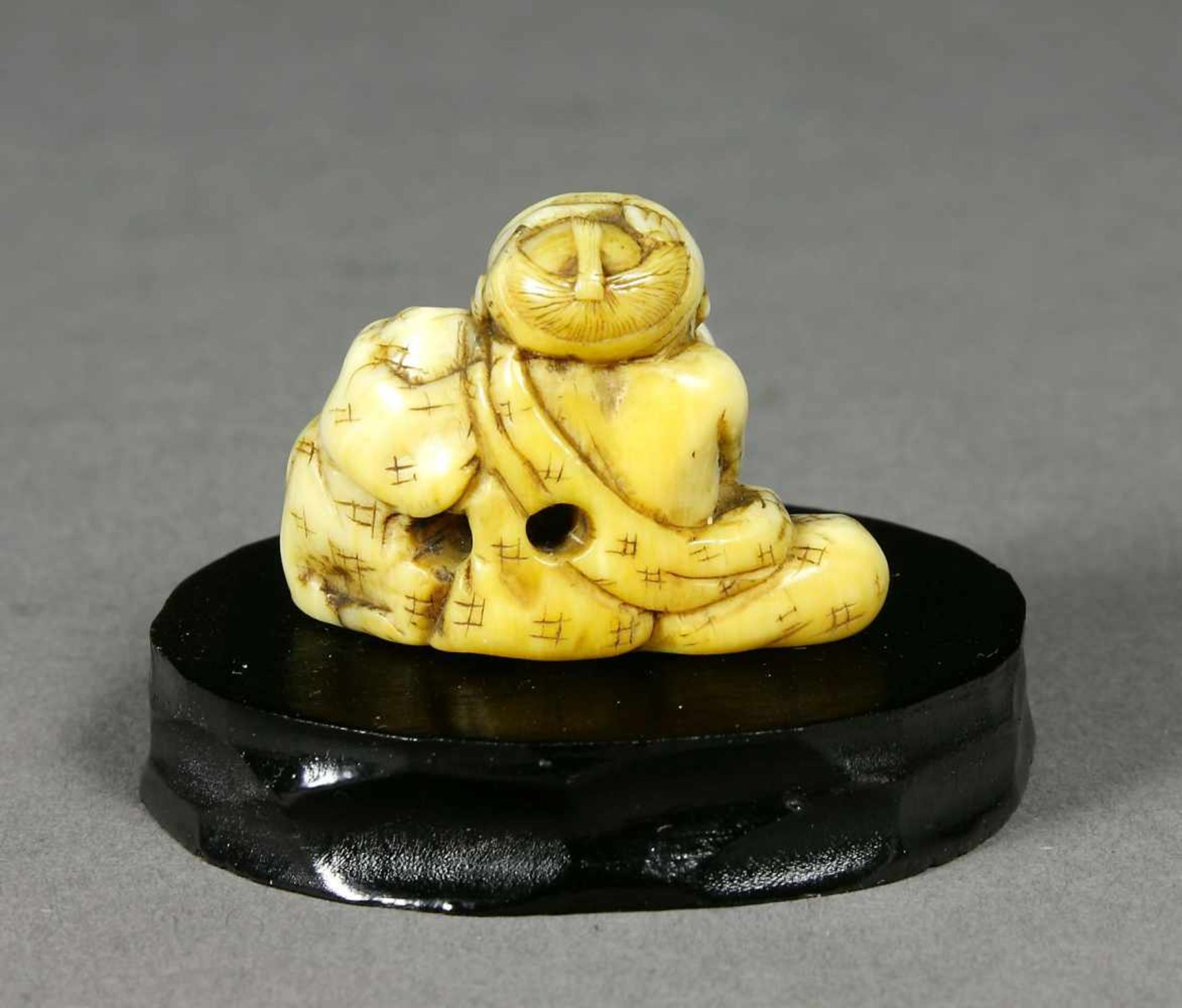 Japan, Netsuke, Elfenbein, MeijiJunge mit Hund. H.: 2,4 cm.