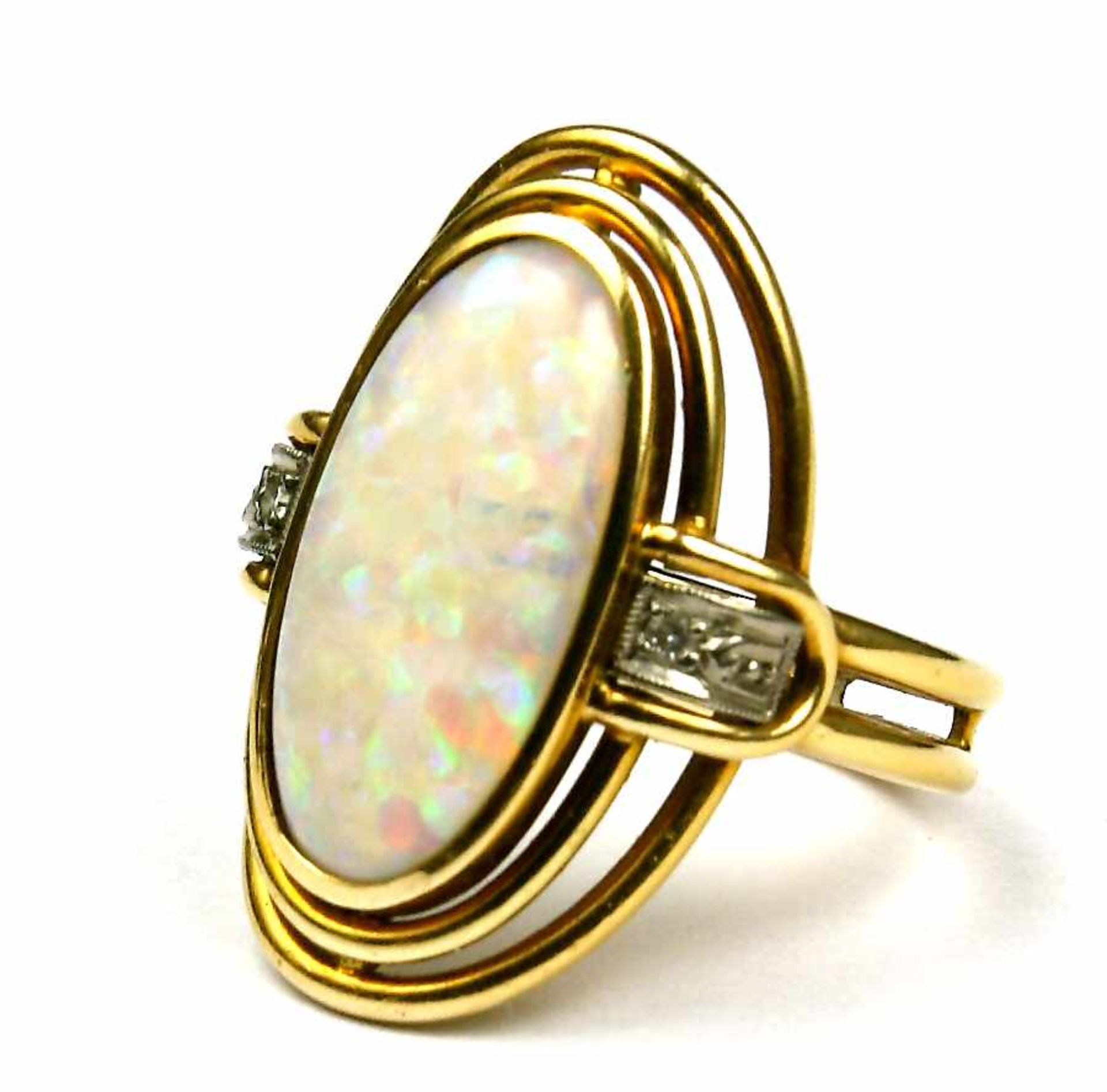 Ring, 750er GG. mit ovalem Opal und zwei begleitenden Diamantrosen. Je zwei schmale Doppelschienen