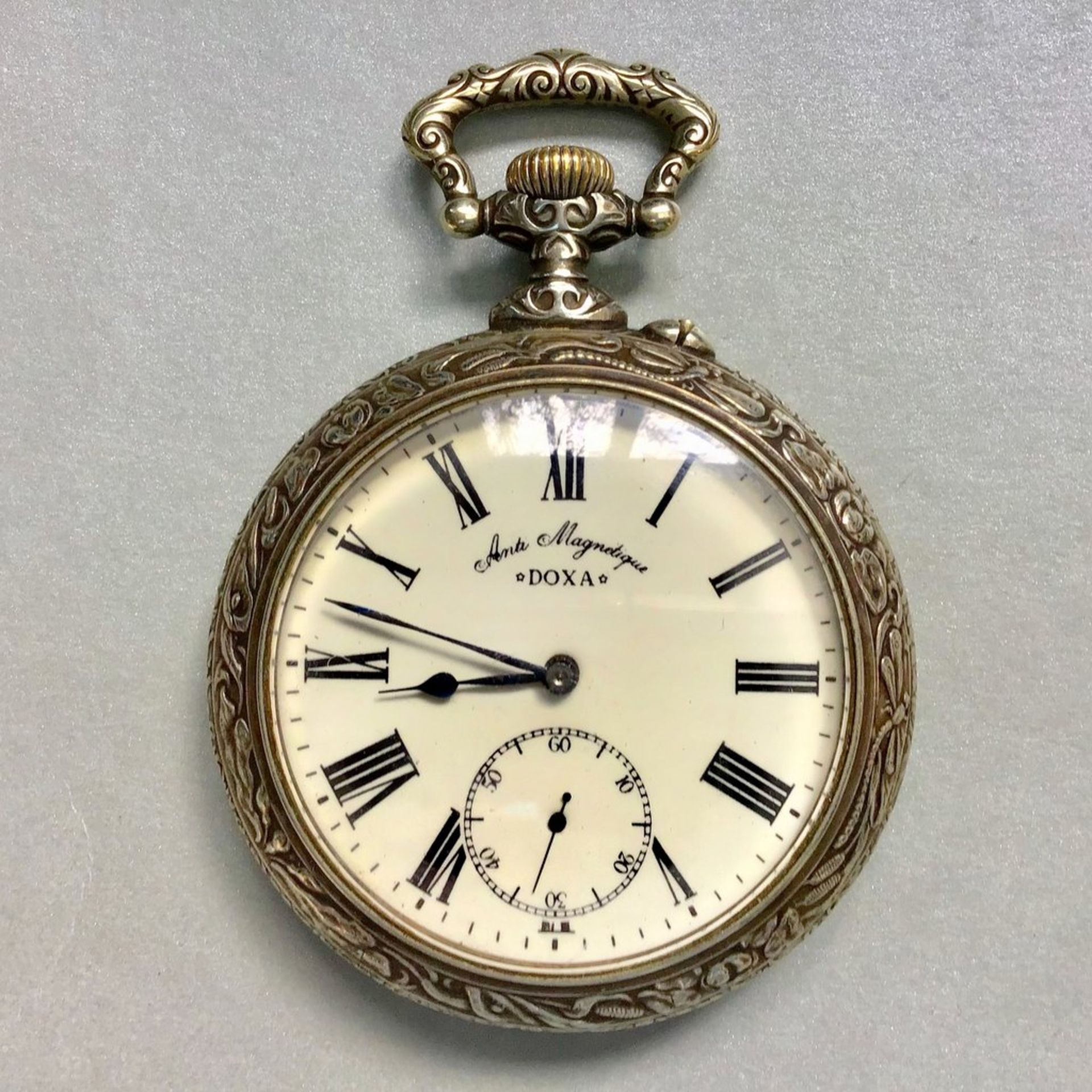 Eisenbahner-Uhr "Doxa", Gehäuse Metall vernickelt Anti Magnetique, um 1908, Rücks. Motiv