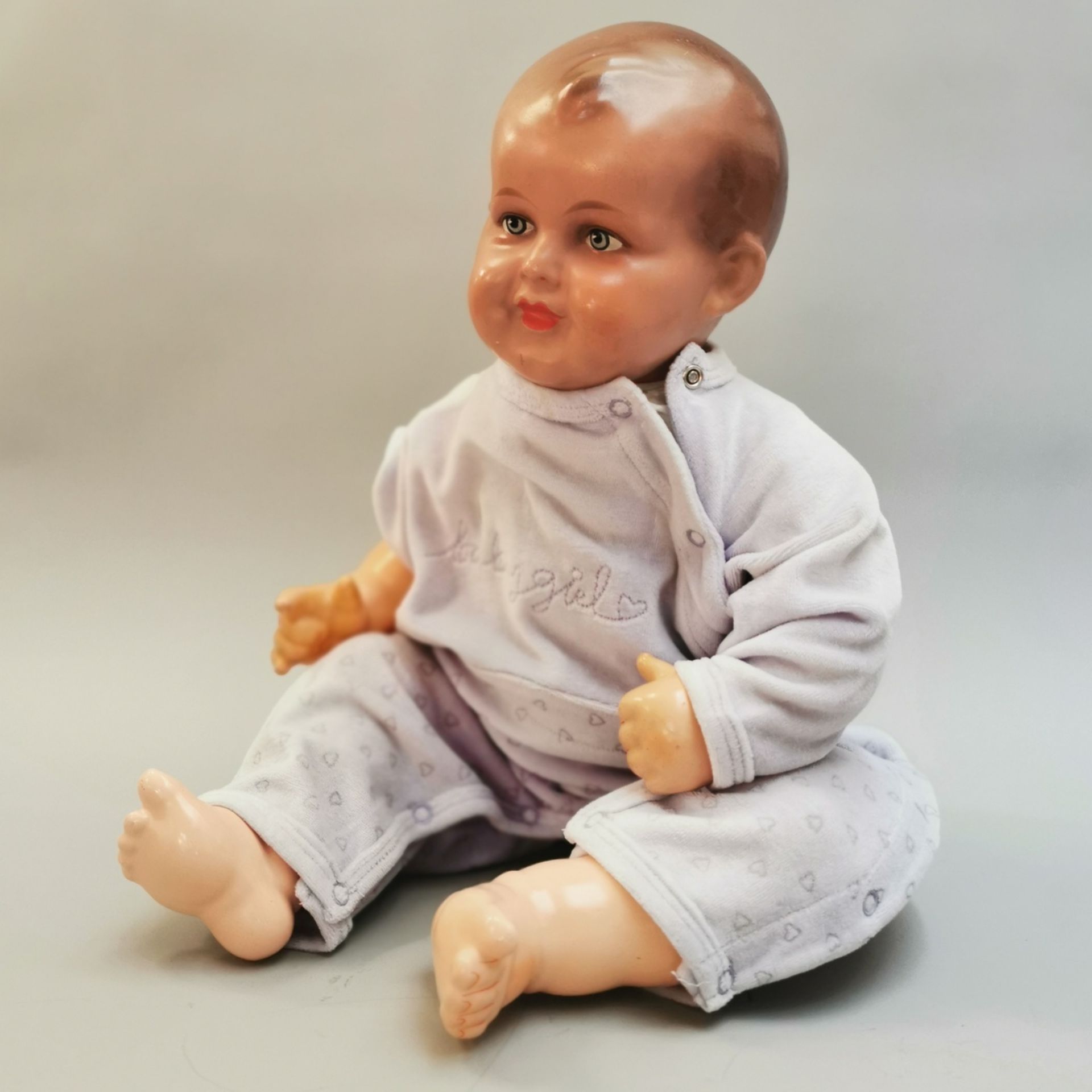 Lebensgroße Babypuppe um 1945, Masse-Einbindekopf, fein gemalte Augen, ungemarkt, Stoffkörper, ein