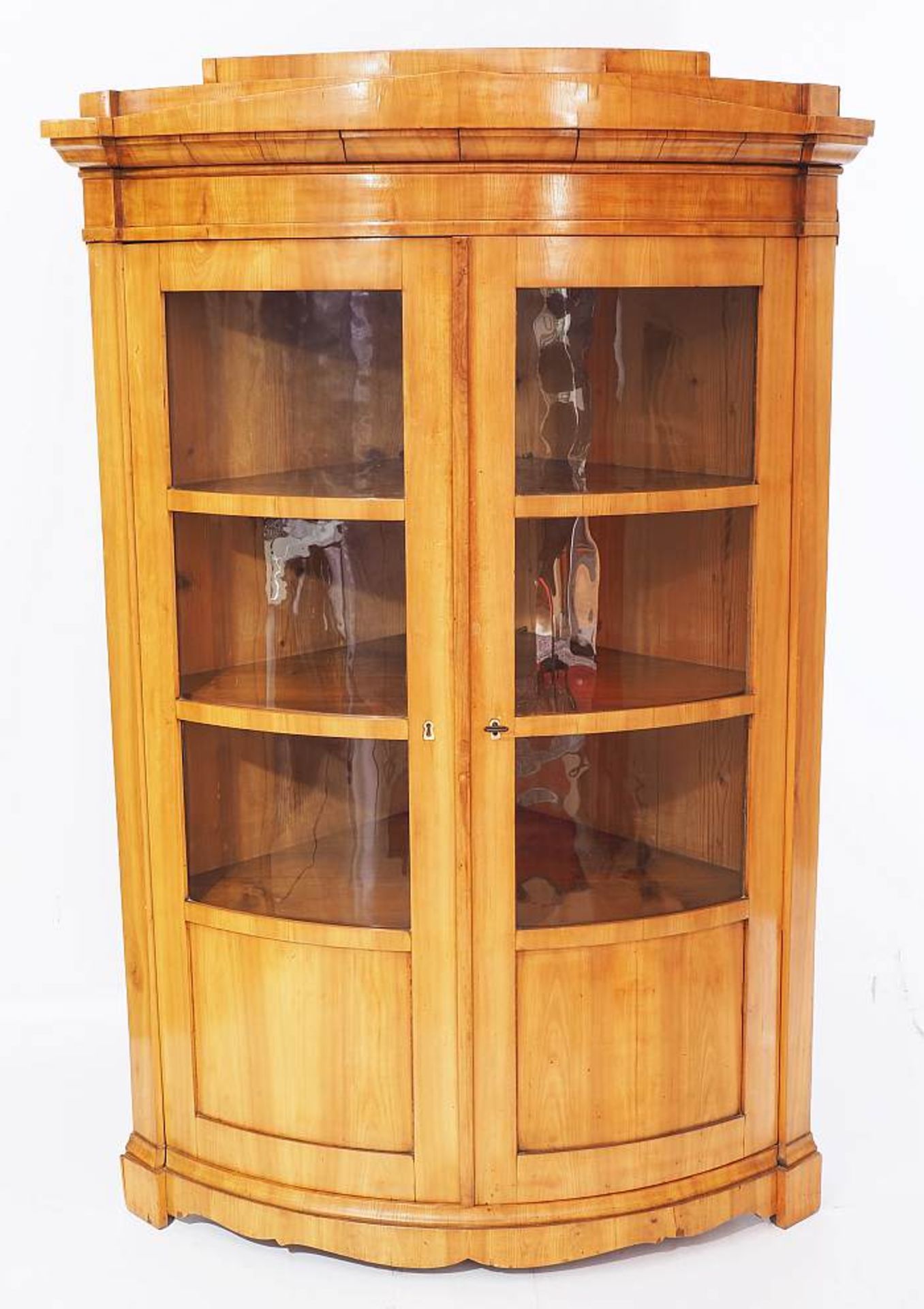 Biedermeier-Eckvitrinenschrank um 1820. Biedermeier-Eckvitrinenschrank um 1820. Kirschholz furniert.