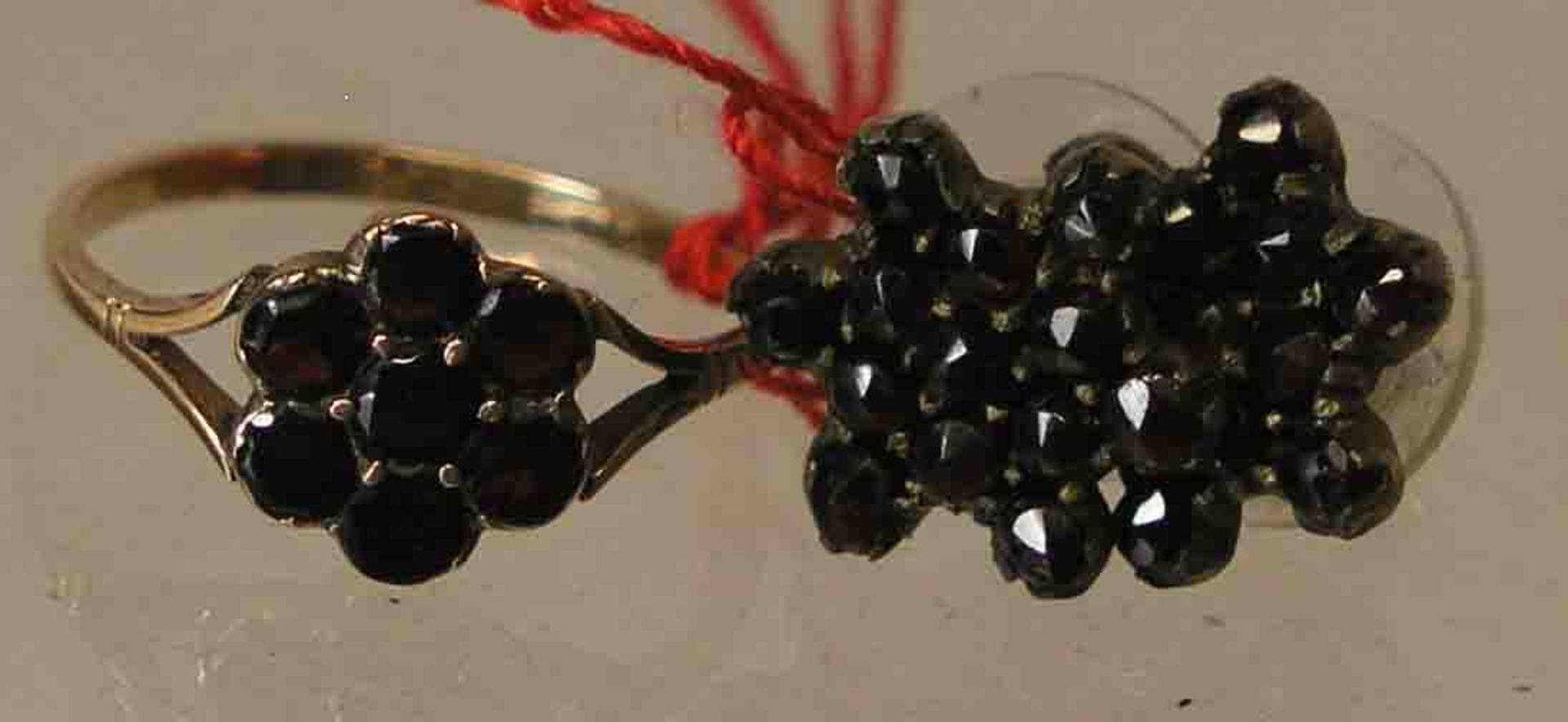 Granatring und Paar Ohrstecker. Schmale Ringschiene mit blütenförmigem Granatbesatz. RG59.