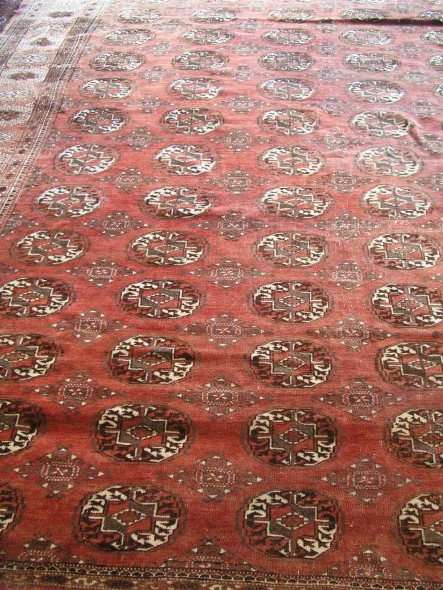 Teppich. Orient. Buchara, weinrot-, beige-grundig. 340 x 260cm; besch.