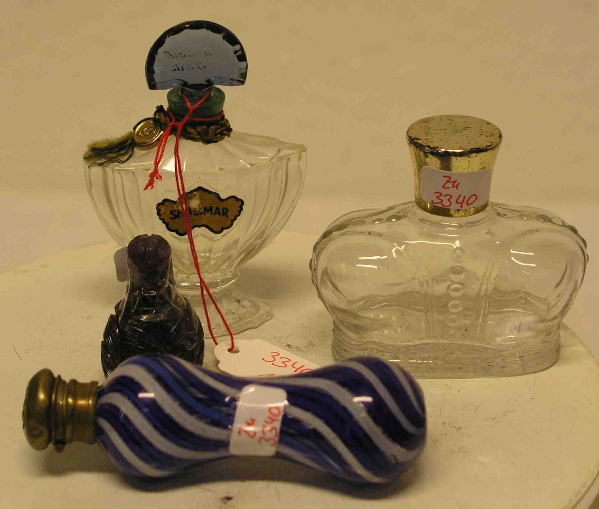 Vier Parfumflakons. Dabei: Prince Matchabelli, Shalimar, blau-weiß gestreiftes Fläschchenund