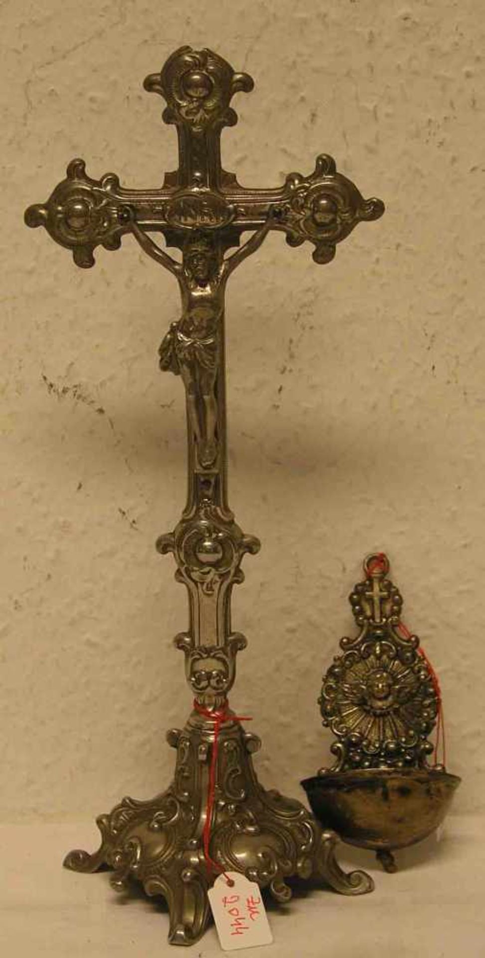 Standkruzifix, um 1900. Metall, Höhe: 29cm; beschädigt. Dazu: Weihwasserbehälter, Höhe:10cm.