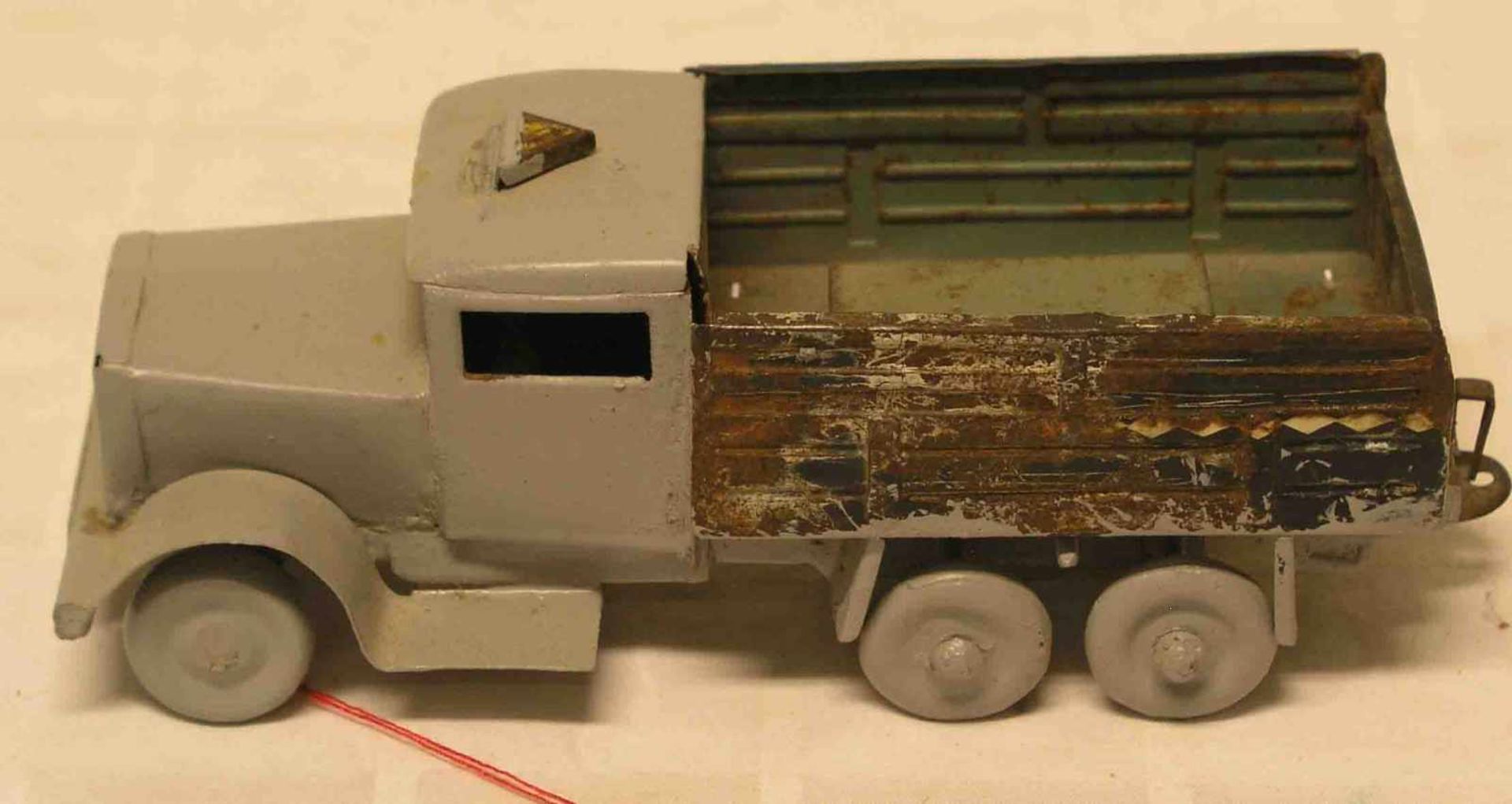 Laster-Auto um 1925. Blech, zum Teil grau lackiert; beschädigt. Länge: 19cm.