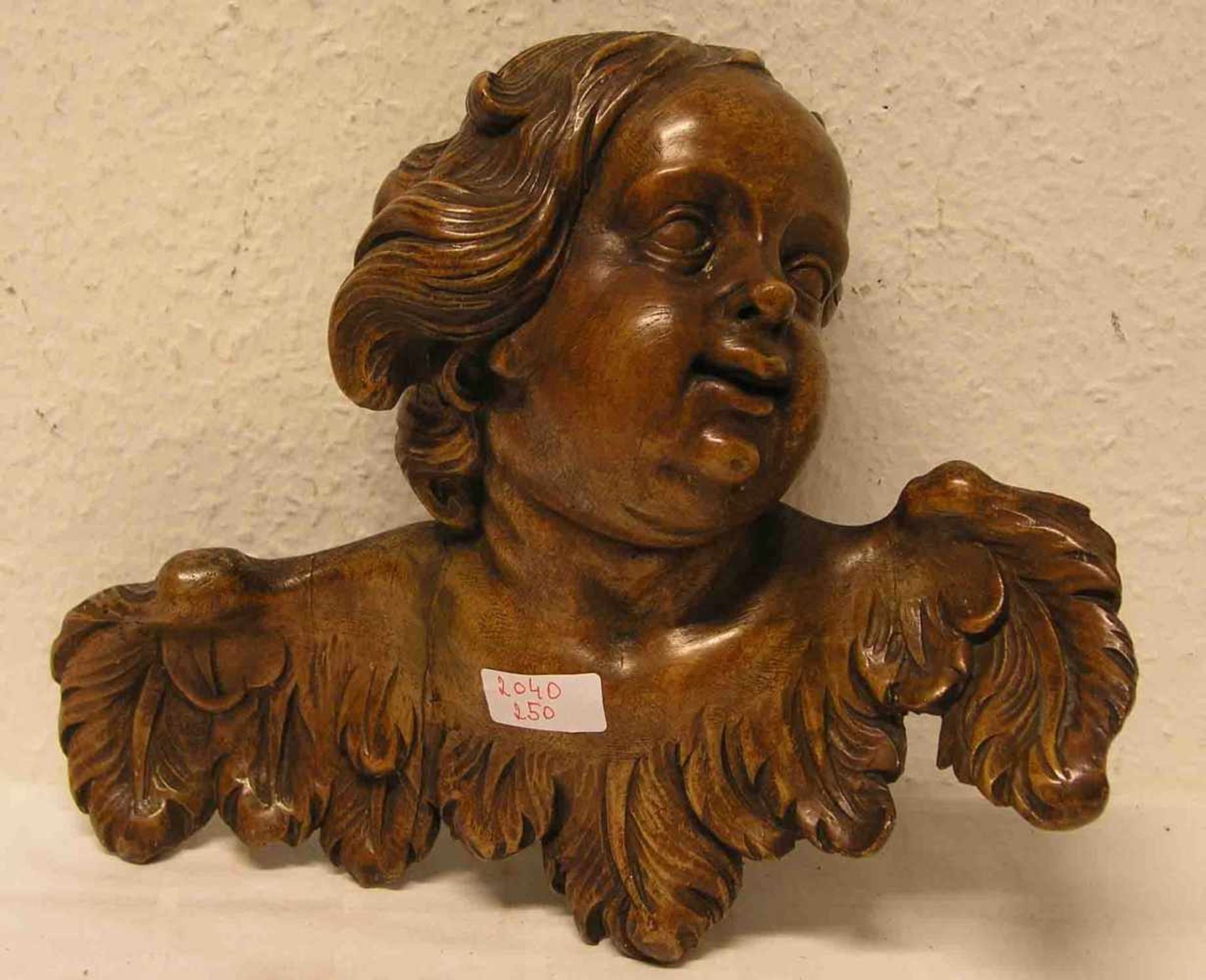 Geflügelter Engelskopf. Holz geschnitzt, um 1800. 25 x 32cm.