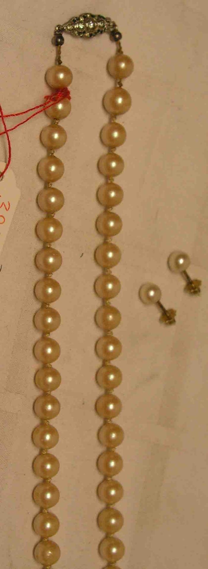 Drei Teile Schmuck. Dabei: Perlenkette, einzeln geknotet, Silberverschluss, Länge: 54cm.Paar