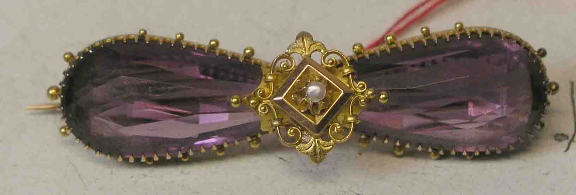 Schleifenförmige Brosche. 14 kt. Gold. Zwei große, facettierte Amethyste, mittigornamental