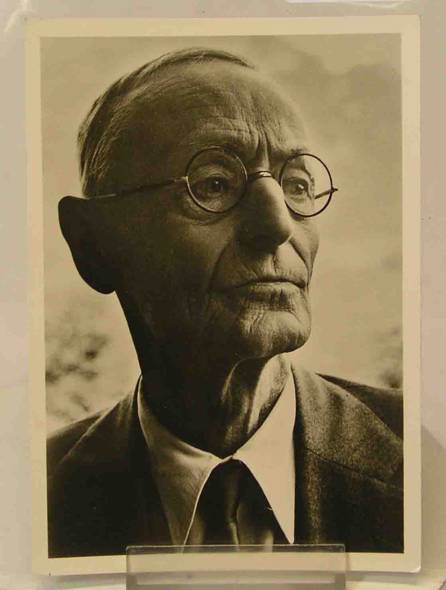 Autogrammkarte Hermann Hesse. Foto und rückseitig "Gute Wünsche", mit Unterschrift. 15 x10cm.- - -