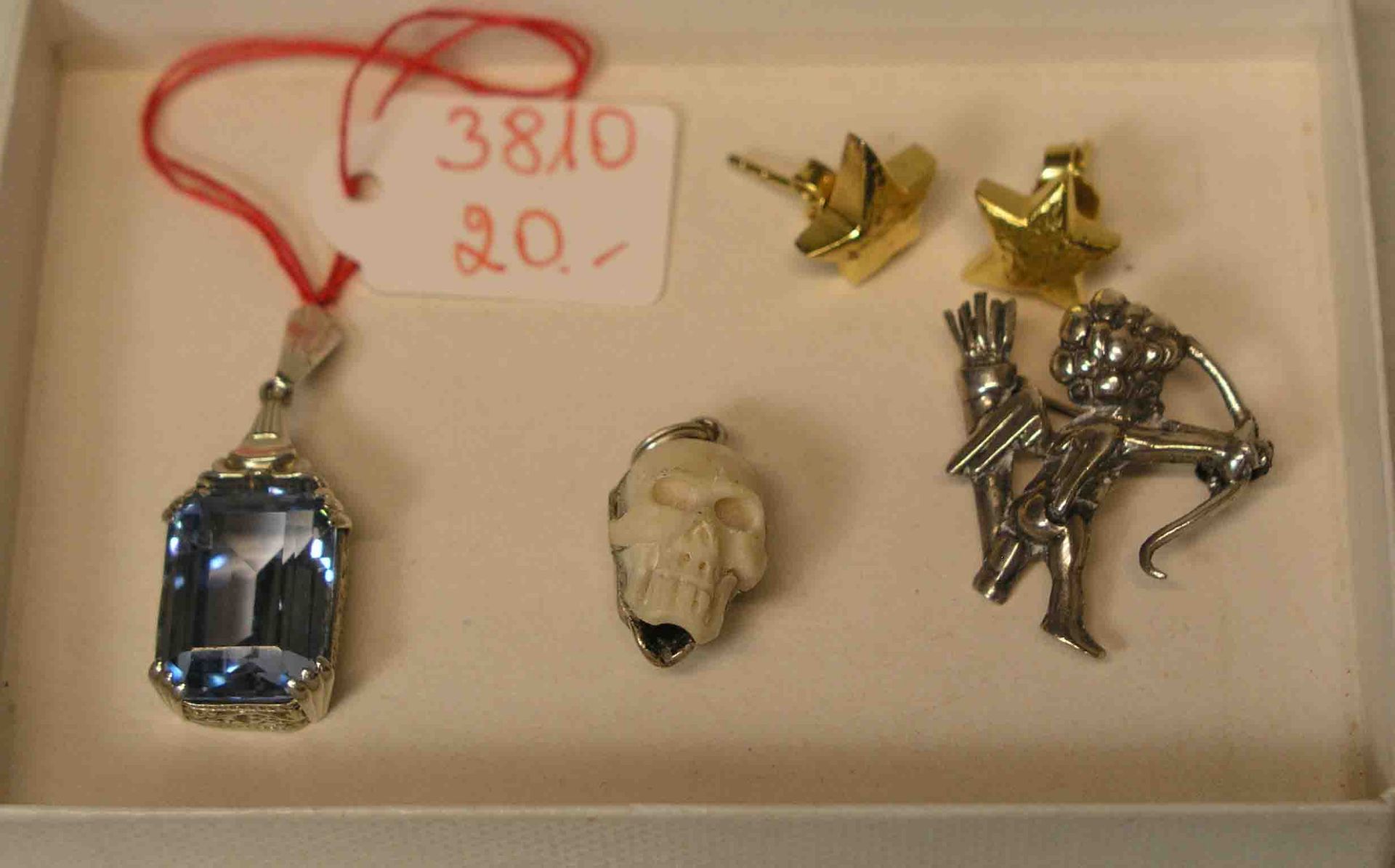 Vier Teile Silberschmuck. Dabei: Brosche, Amor-Motiv, Höhe: 2,5cm. Anhänger: Totenkopf.Anhänger