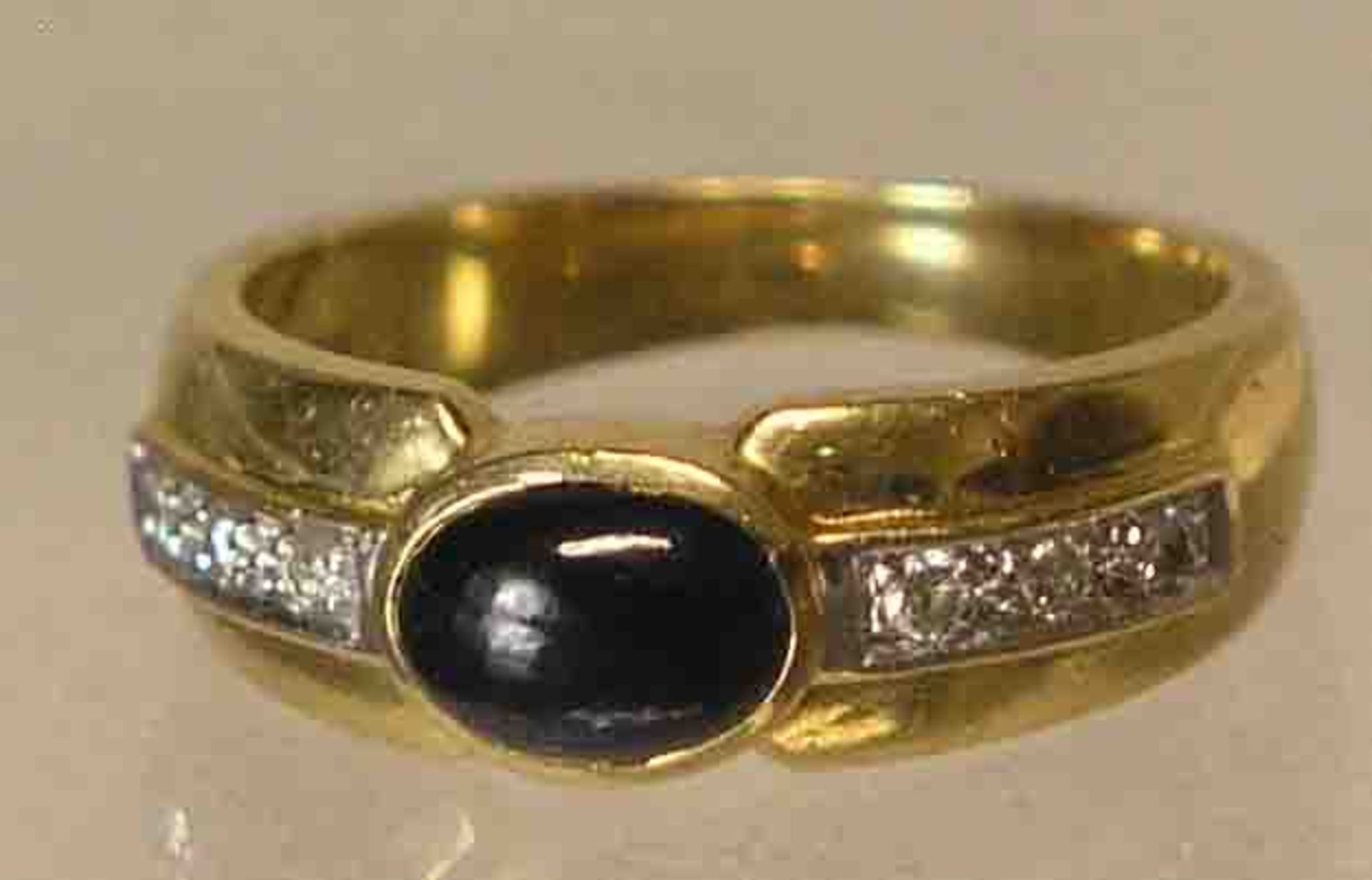 Bandring. 18 kt. Gold. Zentraler Saphir-Cabochon, flankiert von je drei kleinenBrillanten. RG 52.