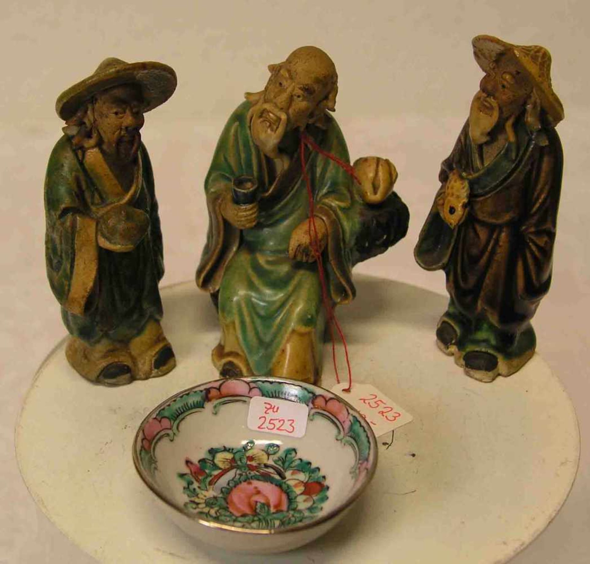 Drei chinesische Figuren. Keramik, bunt glasiert. Höhe: je ca. 10,5cm. Dazu: kleinesSchälchen,