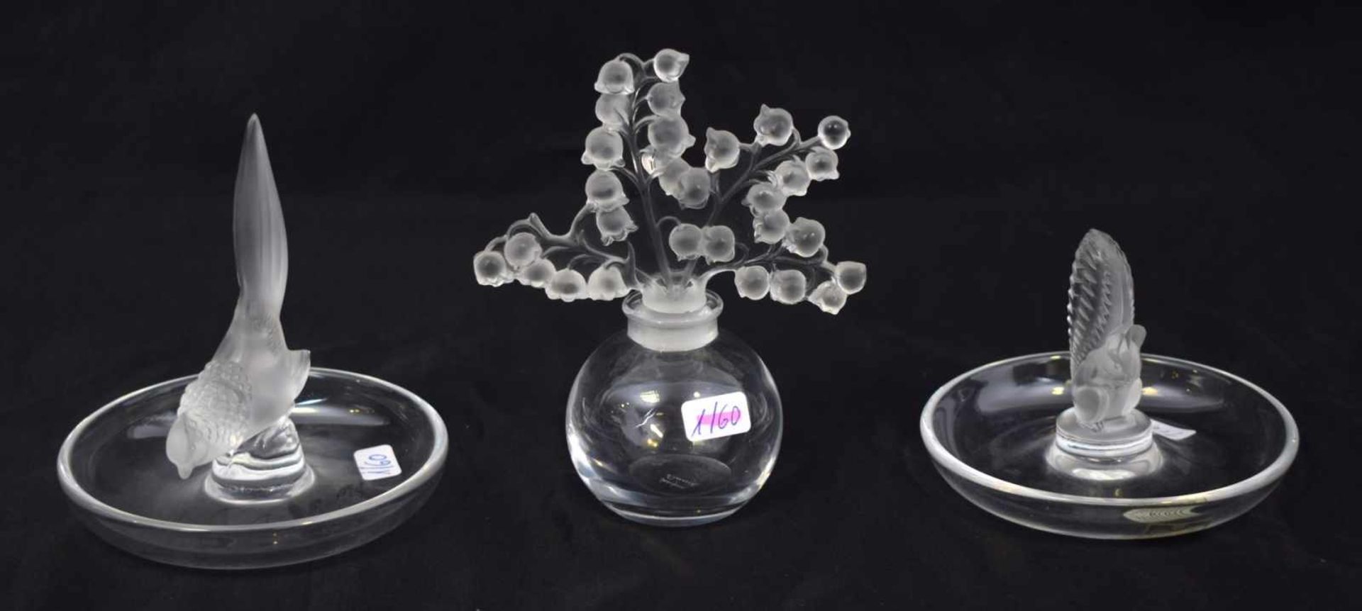 Flakon und zwei Zierschalenfarbl. Glas, Flakonverschluss in Form von plastischen Blüten, runde