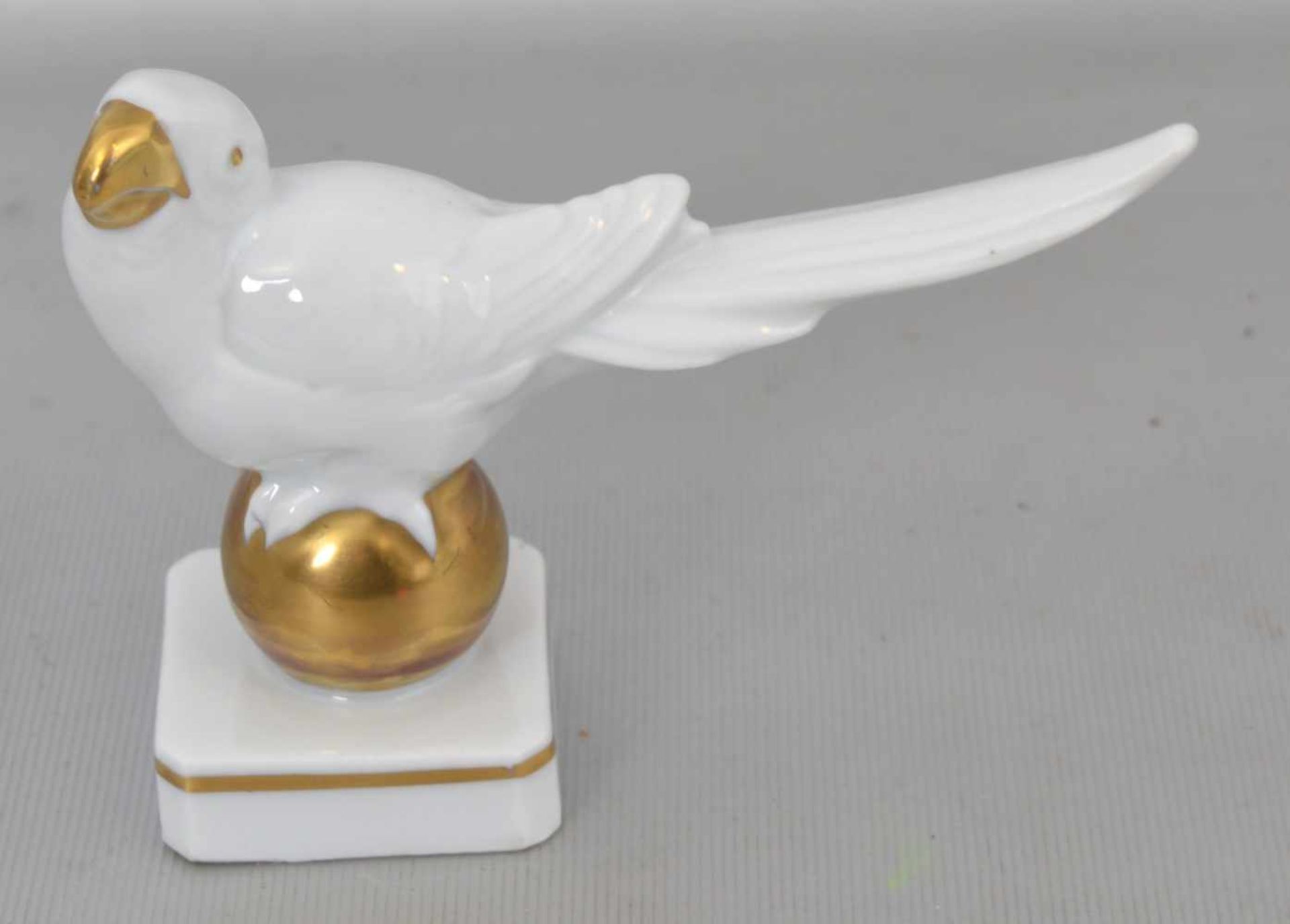 Kleiner Vogelauf rechteckigem Sockel, auf goldener Kugel, H 9 cm, L 13 cm, FM Ens