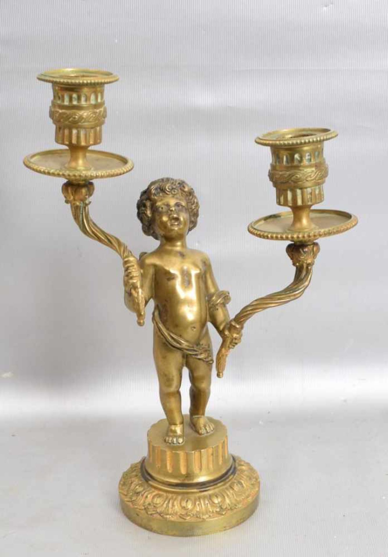 Kerzenleuchter2-lichtig, Bronze, auf rundem verzierten Sockel stehender Putto, mit zwei Leuchtern, H