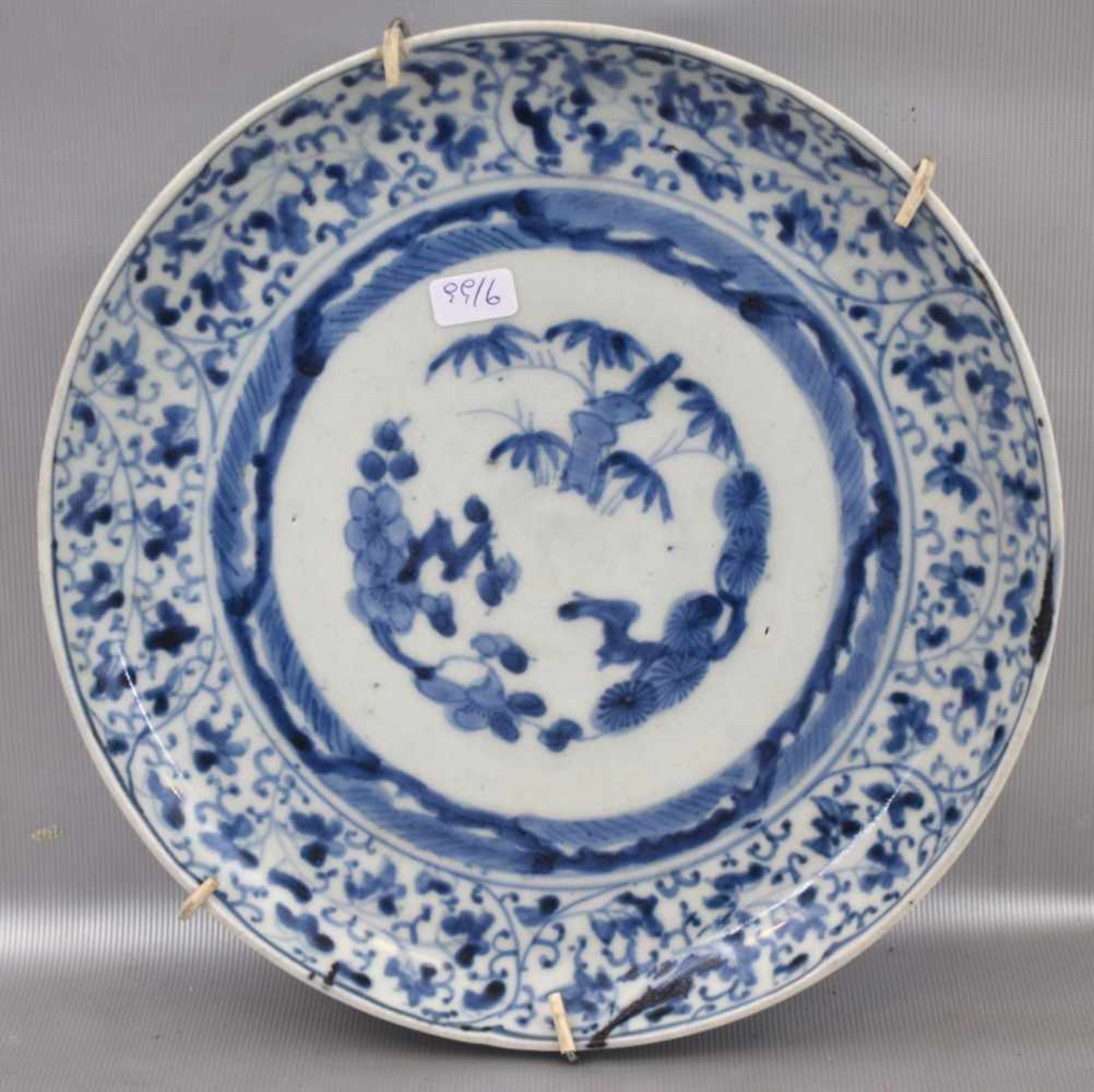 Wandtellerbeigefarben, blau verziert, rückseitig mit asiatischen Zeichen, Dm 21 cm, um 1900