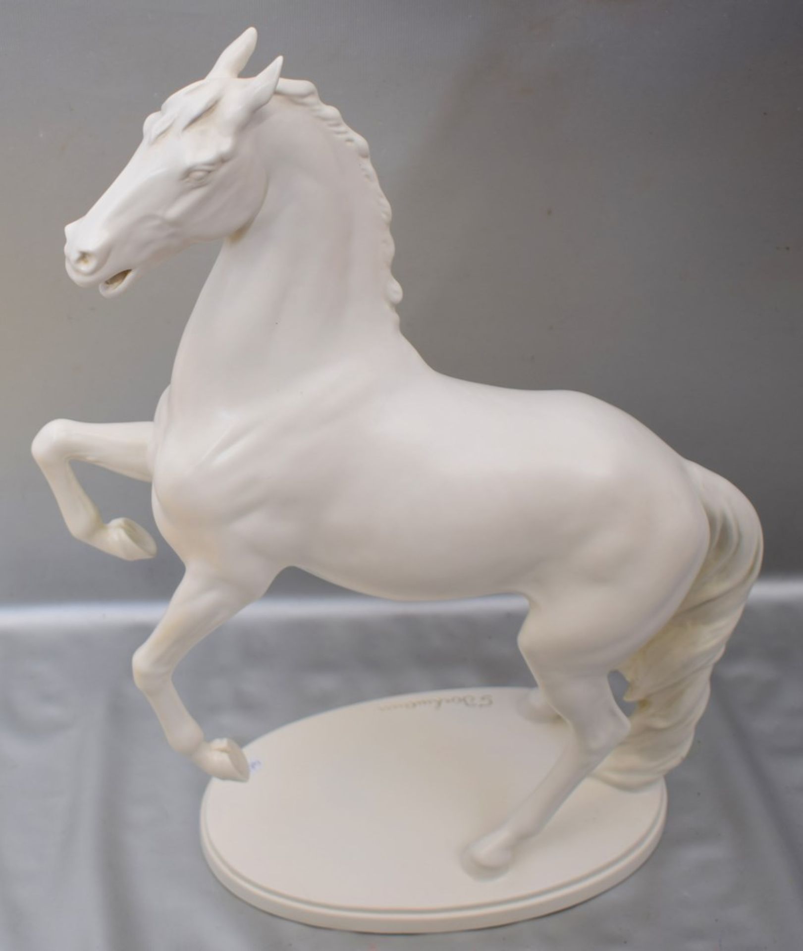 Springendes Pferdauf ovalem Sockel stehend, weiß glasiert, im Sockel sign. Bockmann, H 45 cm, FM