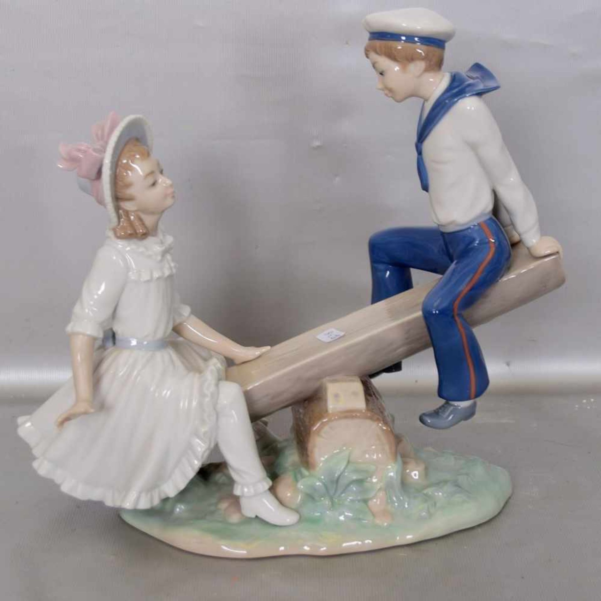 Geschwisterpaar auf Wippeauf ovalem Sockel, bunt bemalt, H 26 cm, L 27 cm, FM Lladro