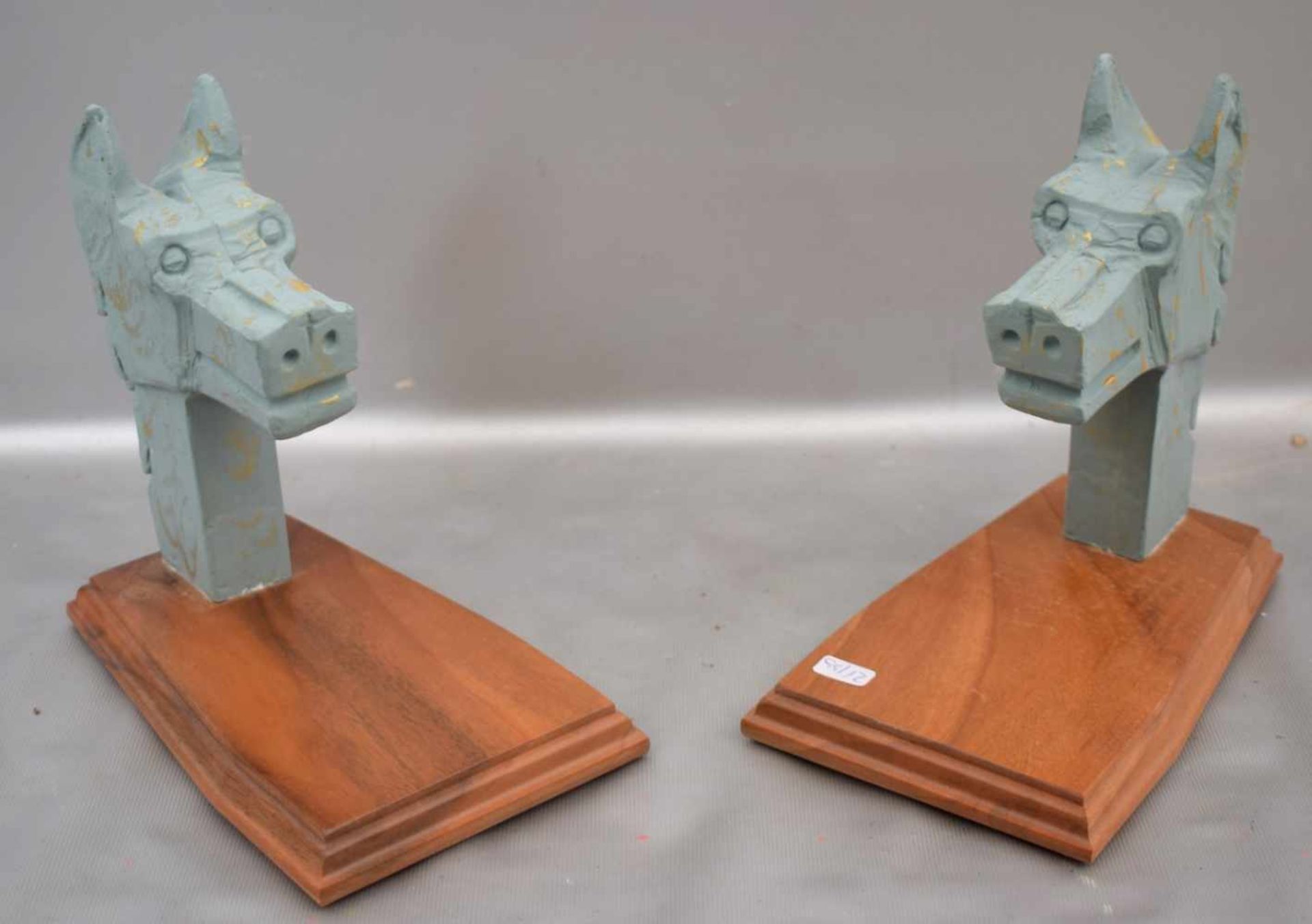 Zwei BuchstützenHartholzsockel, zwei Hundeköpfe, Gips, blau/beige gefasst, im originalen Karton