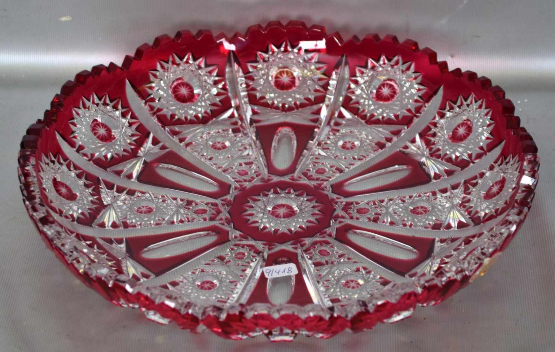 Gebäckplattefarbl. Glas, geschliffen verziert, mit rotem Überfang, gezackter Rand, Dm 28 cm