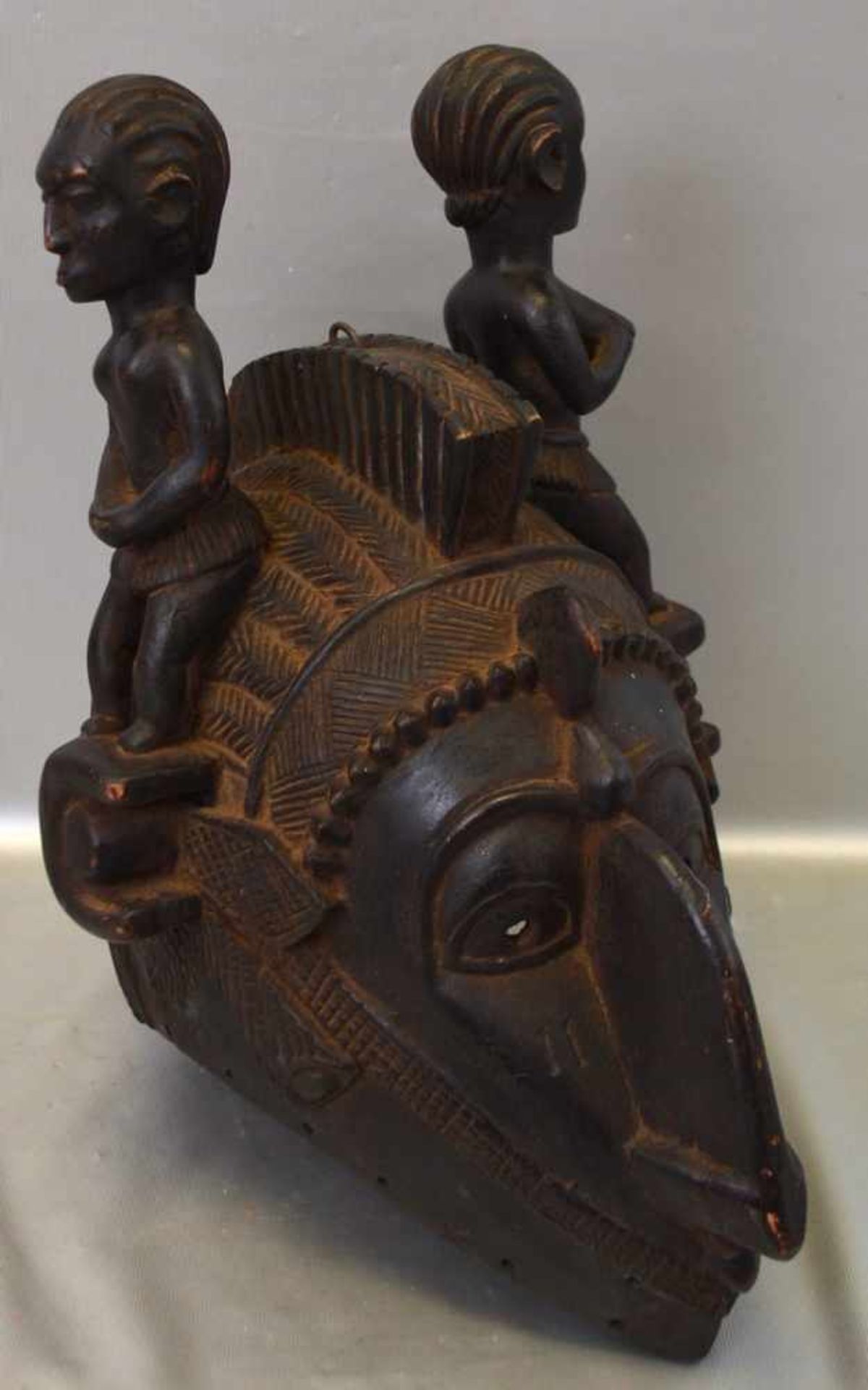Afrikanische MaskeHartholz, aufwendig geschnitzt, mit figürlichen Darstellungen verziert, H 36 cm, L