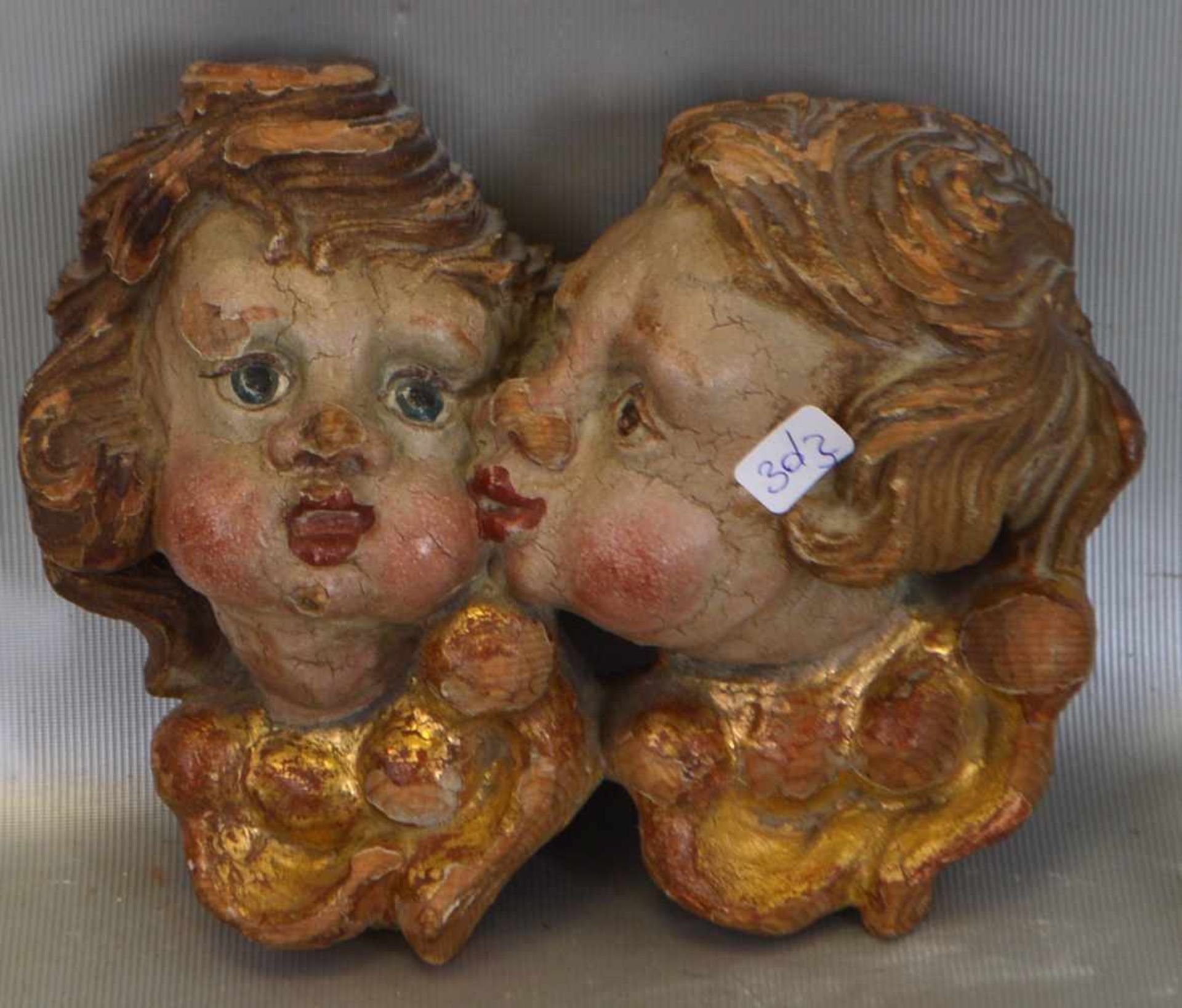 Zwei PuttoköpfeHartholz, geschnitzt, polychrome Fassung, H 14 cm, B 18 cm, um 1900