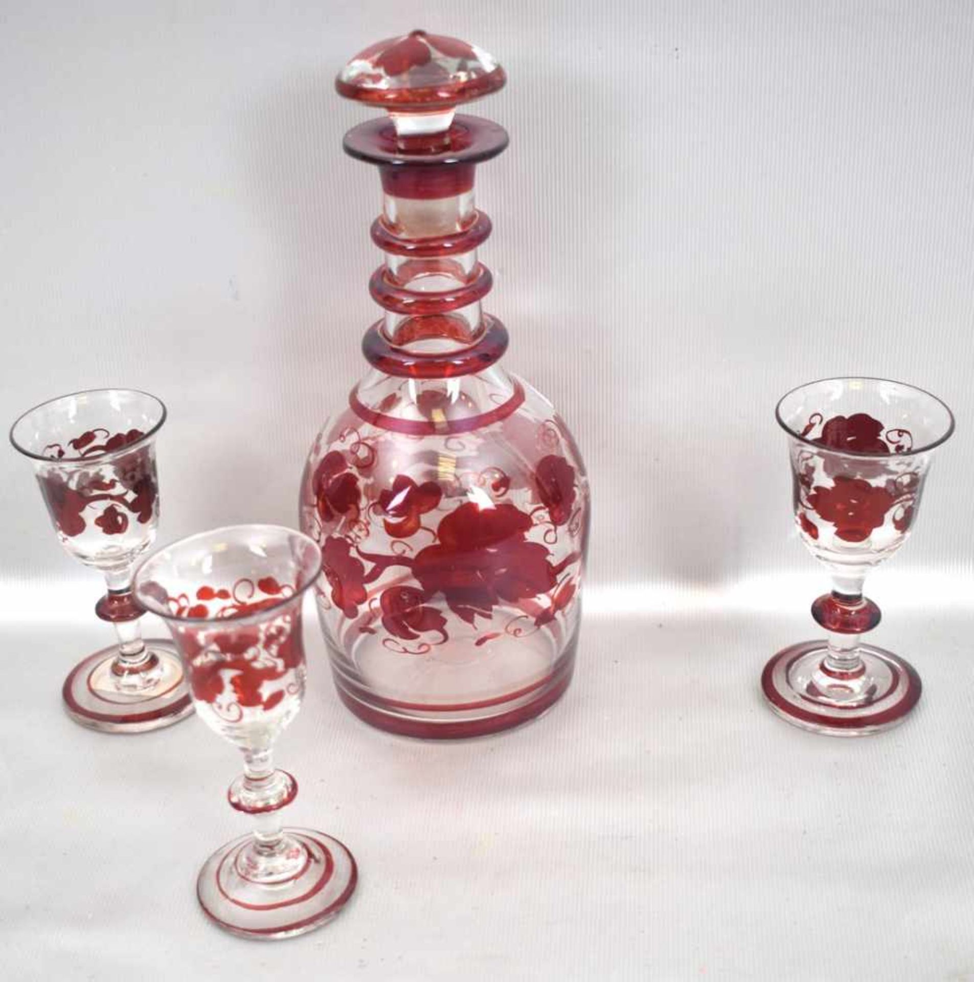 Karaffe und drei Gläserfarbl. Glas, mit roten Ranken verziert, H 19 cm, 19. Jh.