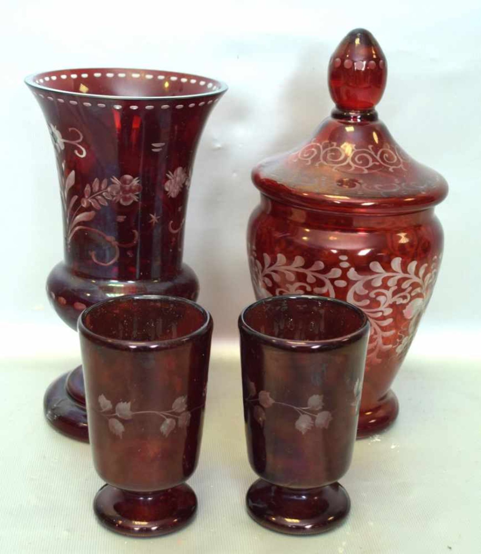 Vase, Deckelgefäß und zwei Becherfarbl. Glas, geschliffen verziert, mit rotem Überfang