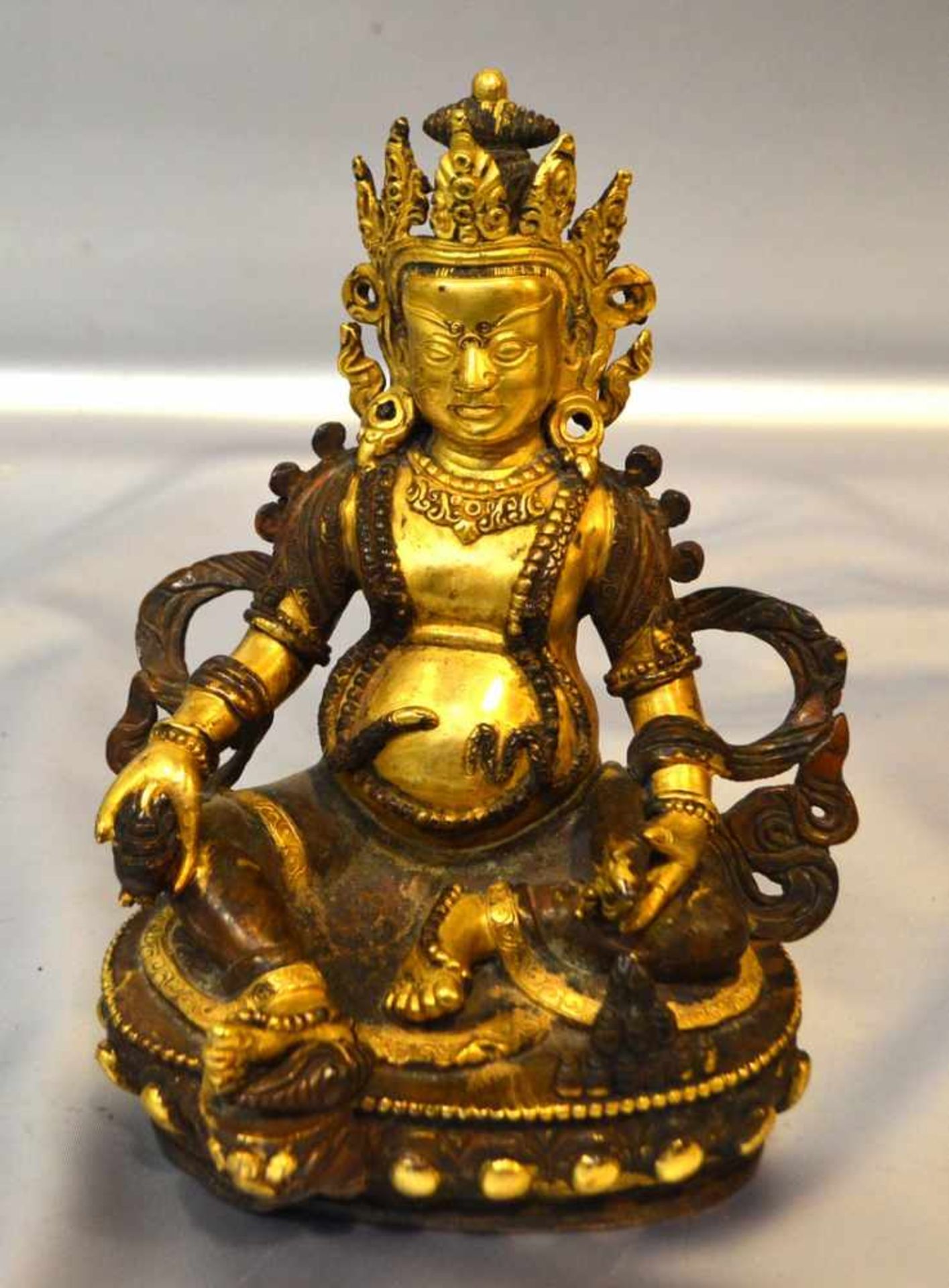 Sitzender BuddhaBronze, vergoldet, auf Lotusblüte sitzend, mit Fisch, teilweise vergoldet, im
