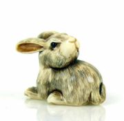 Netsuke (Japan, um 1900)"Hase" den Kopf nach hinten gewendet, sitzend; Elfenbein; geritzt und