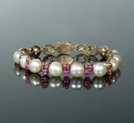 Armkette14ct GG; besetzt mit 12 Perlen sowie 22 hellen Rubinen; Bruttogewicht: 22g; L: 18,5 cm