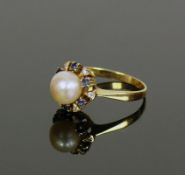 Damenring18ct GG; zentral mit Perle besetzt; diese umrahmt von jeweils 6 kleinen Saphiren und