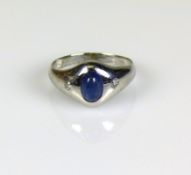 Damenring18ct WG; besetztmit ovalförmigem blauem Stein; seitlich jeweils 1 sehr kleiner Diamant
