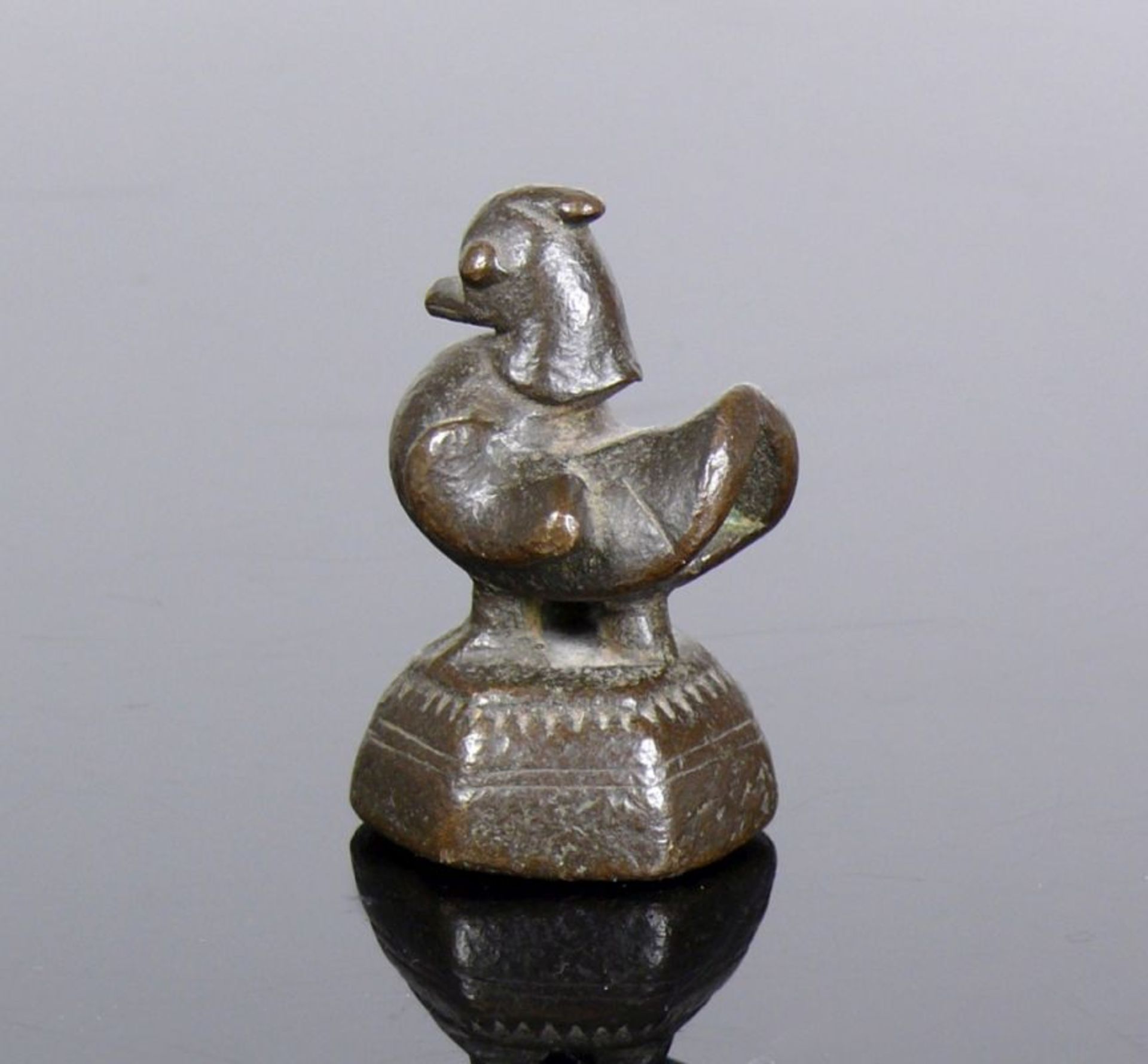 Burmesischer Gewichtsstein (Burma, um 1900)Huhn auf hektogonalem Sockel; Bronze, dunkel patiniert;