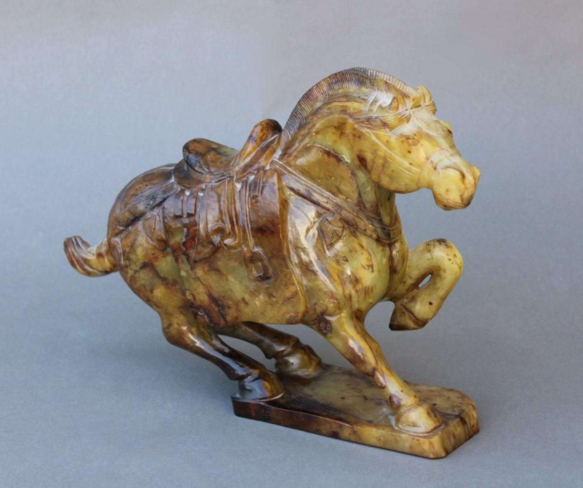 Große Jade PferdefigurChina um 1900, vollplastisch gearbeitetes Pferd mit Sattel und Zaumzeug, auf