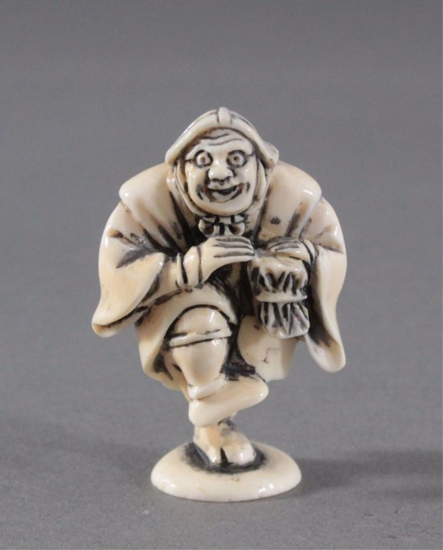 Netsuke, Japan 1. Hälfte 20. Jh., Elfenbein geschnitztMusizierender Mann, signiert, ca. 5,3 x 3,4