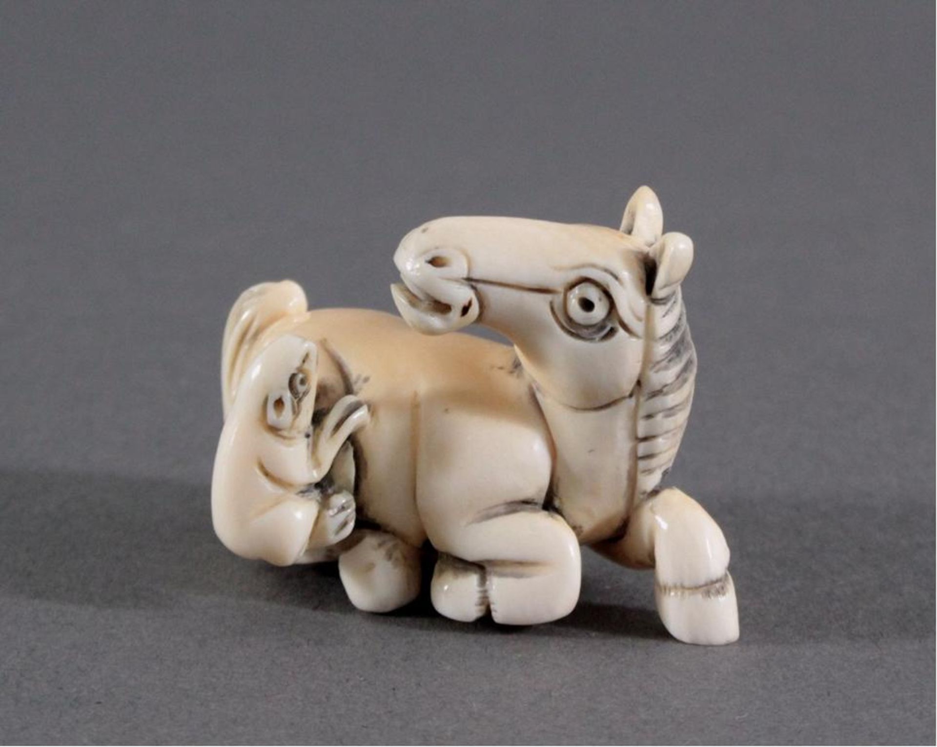 Netsuke, Japan 1. Hälfte 20. Jh., Elfenbein geschnitztLiegendes Pferd mit Ratte, signiert, ca. 2,6 x