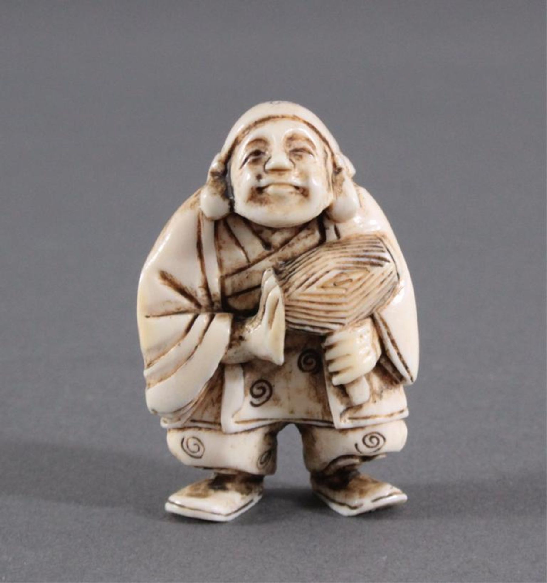 Netsuke, Japan 1. Hälfte 20. Jh., Elfenbein geschnitztMusizierender Mann, ca. Höhe 5,1 cm