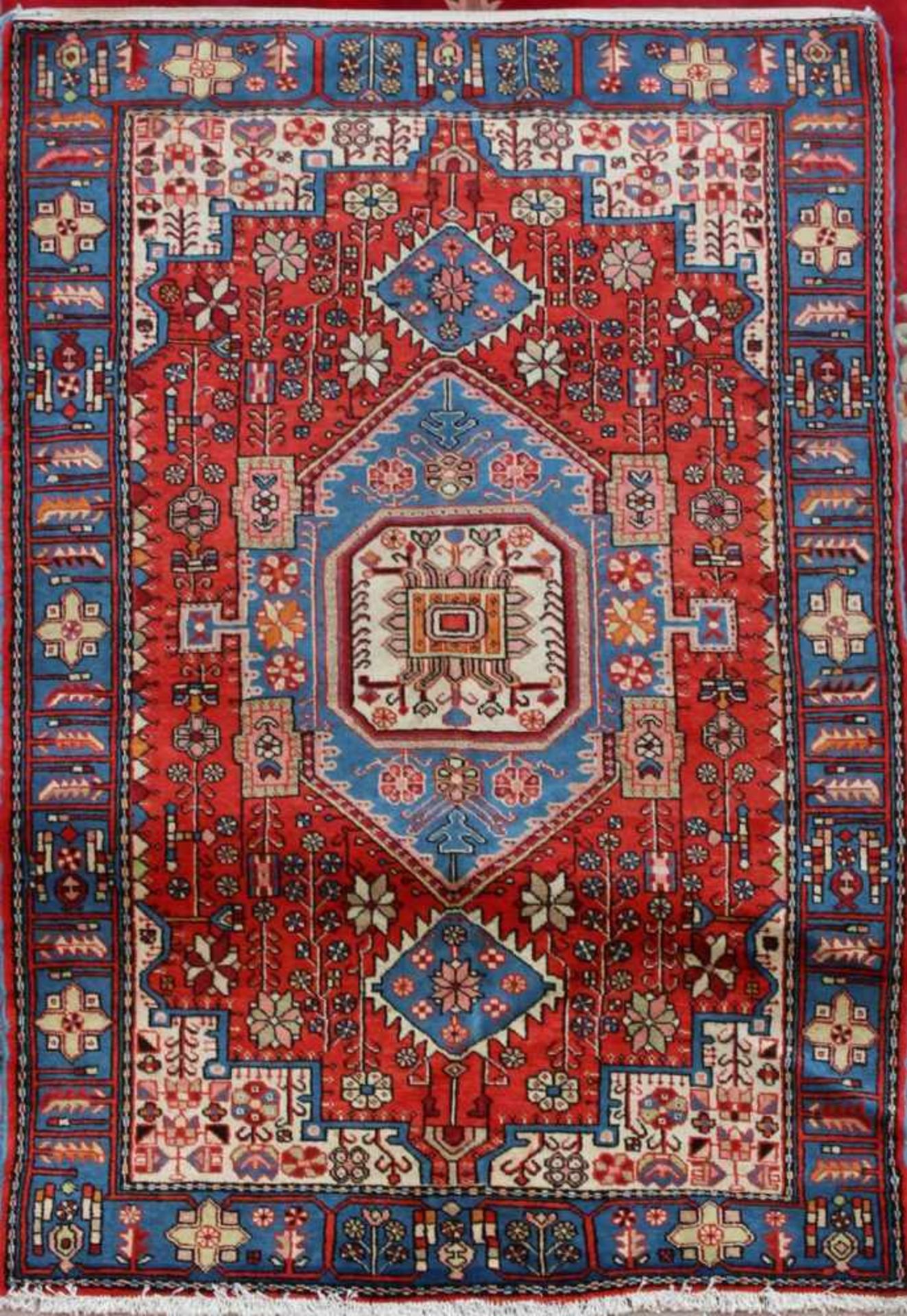 Orient-TeppichMotiv überwiegend in roten und blauen Tönen, ca. 190 x 130