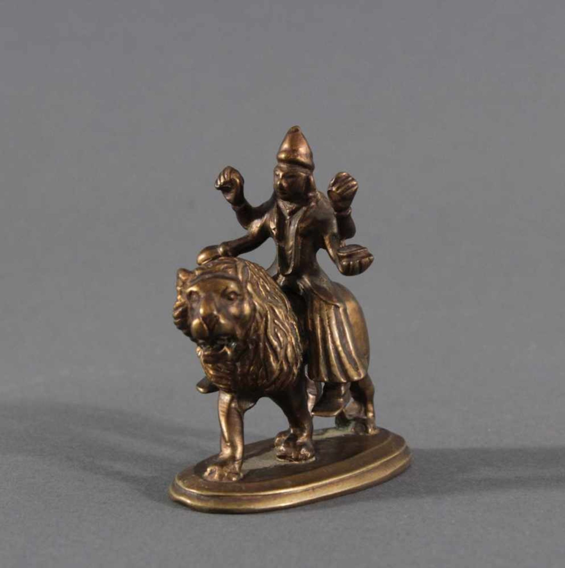 Bronzefigur, "Durga", um 1900Vierarmige Durga auf einem Löwen. In den Händen verschiedene Atribute
