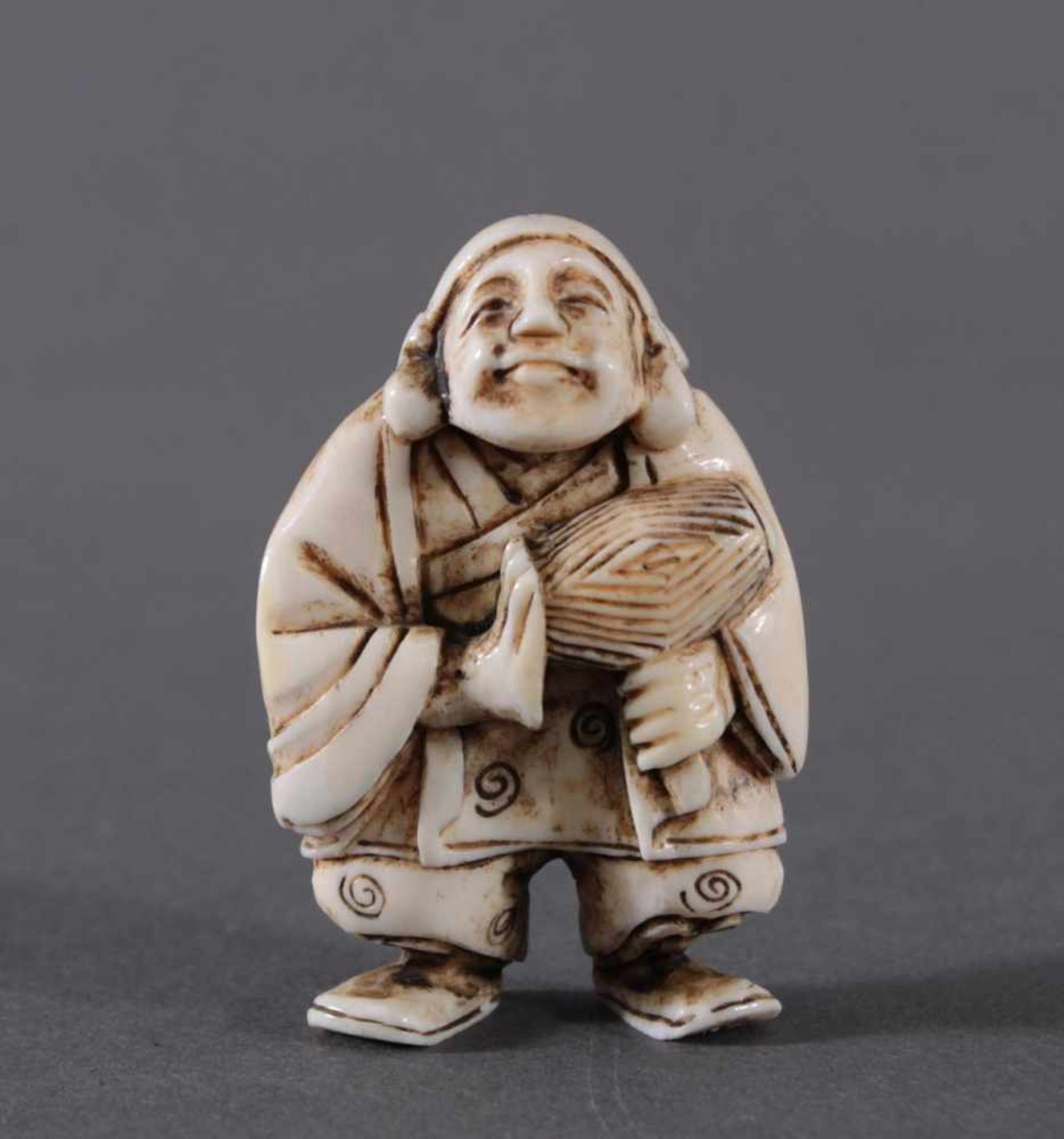 Netsuke, Japan 1. Hälfte 20. Jh., Elfenbein geschnitztMusizierender Mann, ca. Höhe 5,1 cm