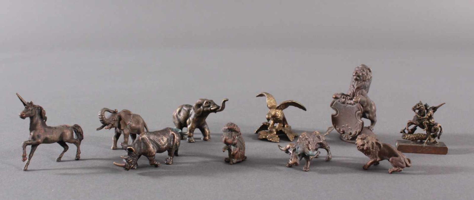 Miniatur Bronzefiguren, 10 Stück1 Löwe mit Wappenschild, ca. Höhe 5 cm. 1 Adler mit ausgebreiteten