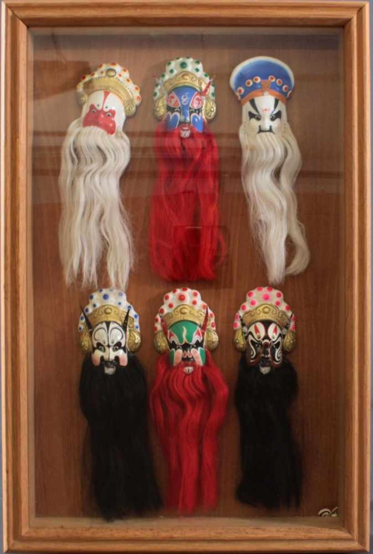 Schaukasten mit 6 Pekinger Opern-MaskenMasken auf Holztafel fixiert, Kastenmaße ca. 61 x 40 cm. 1