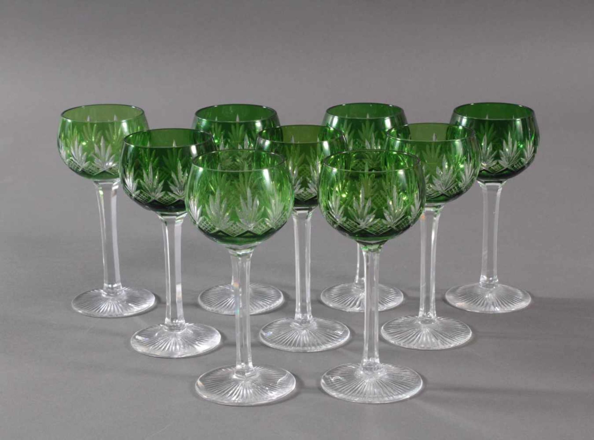 9 Kristall-RömerKristallglas, grün überfangen und reich beschliffen, facettierter Schaft, ca. H-17,5