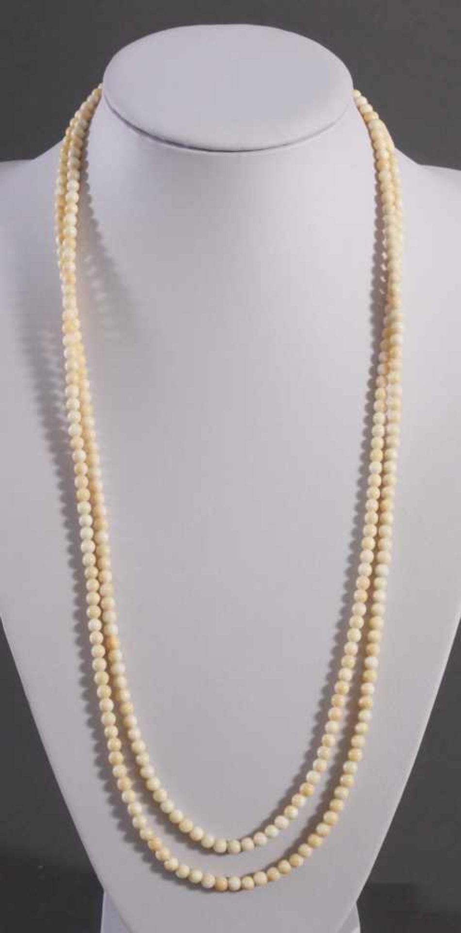 Halskette aus ElfenbeinkugelnAus mehr als 300 Kugeln (D-0,5 cm) aufgefädelt, Drehschließe, ca. Länge