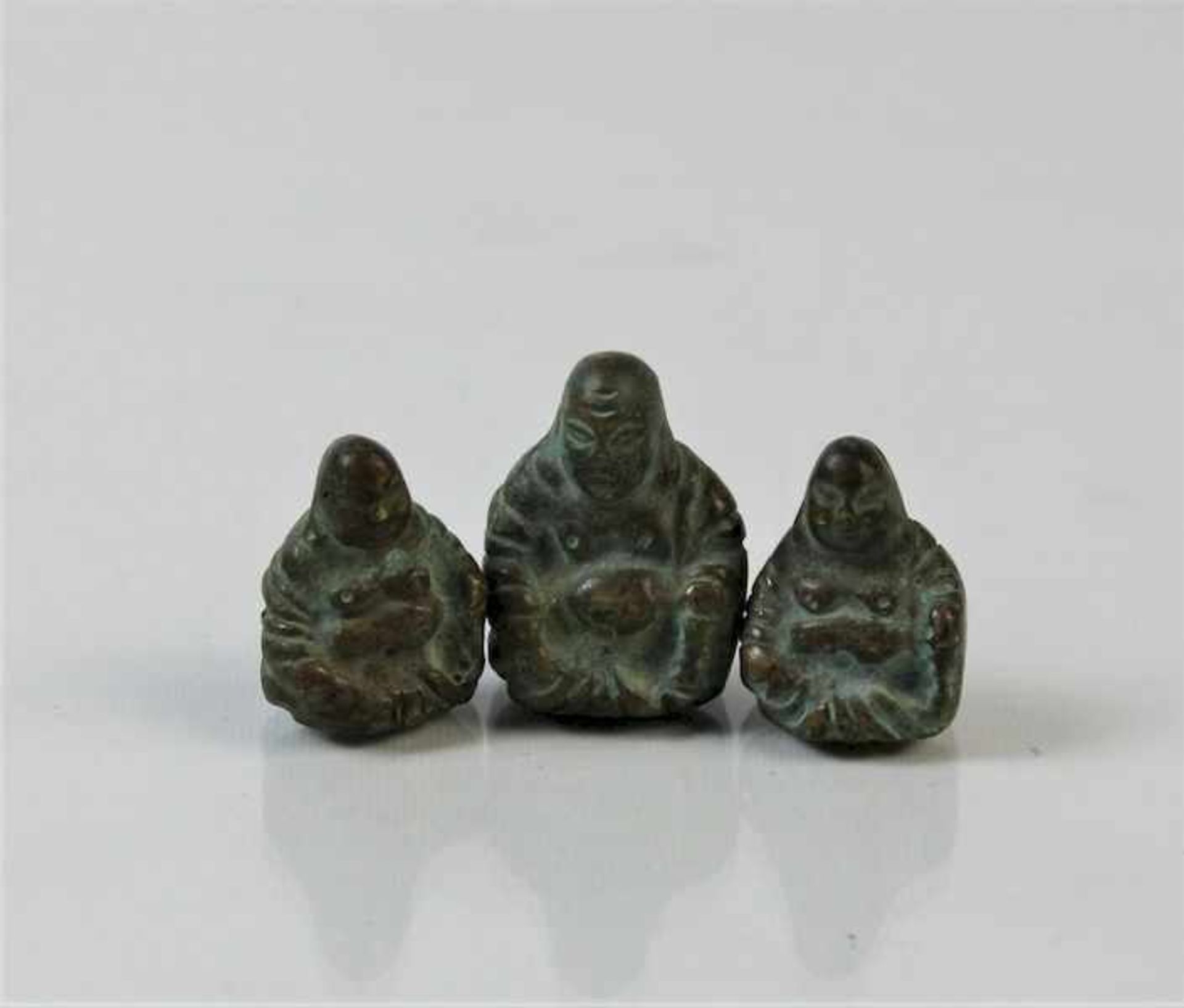 3 kleine Buddhafiguren, 1. Hälfte 20.Jhdt.Bronze am Boden beschriftet Maße: ca. H. 2,5 cm bis 3 cm