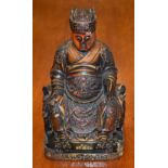A Chinese polychrome lacquer figure, of an official, seated, wearing robes of rank and office,